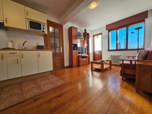 17C01 Apartamento Caravia في كارافيا: مطبخ مع دواليب بيضاء وغرفة معيشة