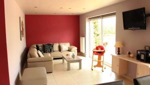 ein Wohnzimmer mit einem Sofa und einer roten Wand in der Unterkunft De Lekkermond in Diksmuide