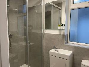 a bathroom with a shower and a toilet and a sink at Modern 6bedroomall ensuite in Birkenhead Free Parking and Wifi in Wallasey