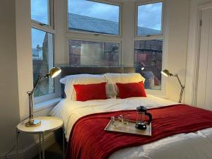 1 dormitorio con 1 cama grande, 2 mesas y 2 lámparas en Modern 6bedroomall ensuite in Birkenhead Free Parking and Wifi en Wallasey
