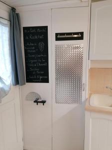 een keuken met een krijtbord aan een muur naast een wastafel bij Le Cottage in Rochefort