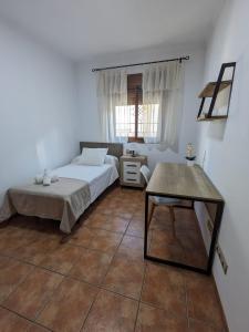 a bedroom with a bed and a table at Chalet La Noria in Nerja