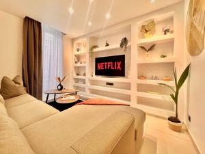 a living room with a couch and a tv at LIBERATION CENTER - PRIVATE Balcony - 24&7 RECEPTION - LUGGAGE STORAGE in Nice