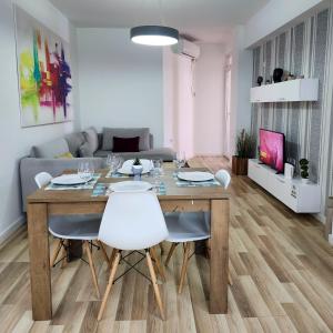 a dining room table and chairs in a living room at 2E Apartment Myslym Shyri in Tirana