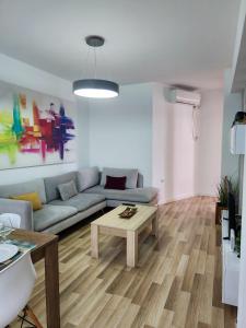 ein Wohnzimmer mit einem Sofa und einem Couchtisch in der Unterkunft 2E Apartment Myslym Shyri in Tirana