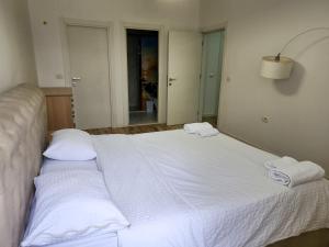 a white bed with two towels on top of it at 2E Apartment Myslym Shyri in Tirana