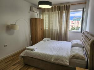 ein kleines Schlafzimmer mit einem Bett und einem Fenster in der Unterkunft 2E Apartment Myslym Shyri in Tirana