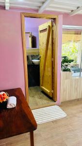 a bathroom with a mirror and a wooden door at Balcones del Paraíso in Baños