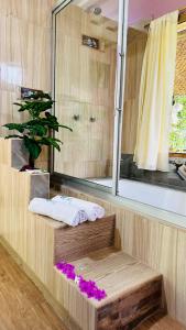 a bathroom with a shower with a mirror and purple flowers at Balcones del Paraíso in Baños