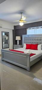 1 dormitorio con 1 cama grande con almohadas rojas en LEAN LUXURY Apartamento en Santo Domingo