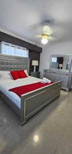 1 dormitorio con 1 cama grande con almohadas rojas en LEAN LUXURY Apartamento en Santo Domingo