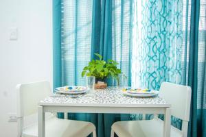 a dining room table with two plates and a plant at Cape Coral 3 in Cabrera