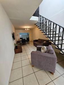 een woonkamer met een bank en een trap bij Casa los Mariachis centro in San Juan de los Lagos