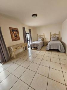 um quarto com 2 camas e piso em azulejo em Casa los Mariachis centro em San Juan de los Lagos
