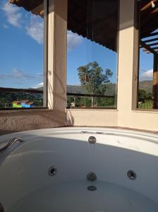 a white bath tub in a room with a window at Chalé Jenipapo in Santana do Riacho