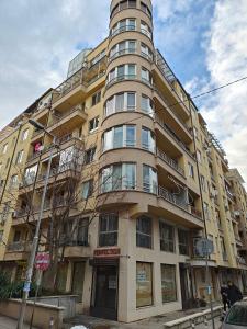 a tall yellow building with balconies on a street at 1 Bedroom Natural Condo in Sofia