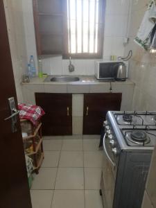 a small kitchen with a stove and a sink at Buzsahm in Dakar