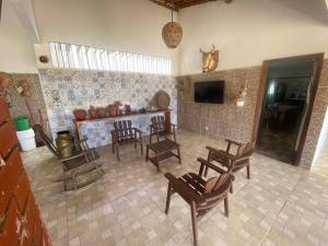 a living room with chairs and a table and a tv at Casa perfeita pra fim de semana e feriadões in Vitória de Santo Antão