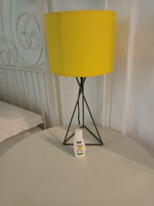 een gele lamp op een tafel naast een bed bij B&B Perla in Catania