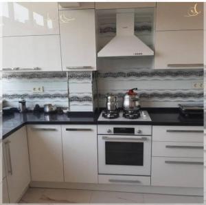 a kitchen with white cabinets and a stove top oven at MY ELIT APARTMAN in Çekme