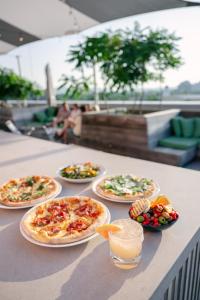 a table topped with pizzas and plates of food at Quirk Hotel Charlottesville in Charlottesville