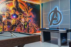 a room with a pool table and a poster of avengers at 150 Stunning 4BD Perfect for Your Vacation in Davenport