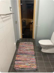 a bathroom with a toilet and a rug on the floor at Lisa Lodge i Järvsö Ski and bike in and out in Järvsö