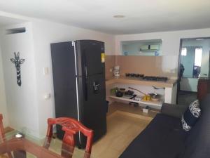 a kitchen with a black refrigerator in a room at El Encanto ApartaSuite in Barranquilla