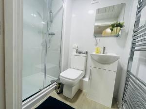 a white bathroom with a toilet and a shower at Sleek & Stylish Stretford Studio for Two in Manchester