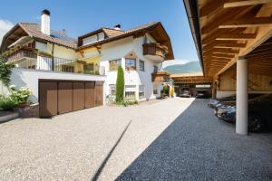 a driveway of a house with cars parked in the driveway at Ferienwohnungen Lanserhof in Appiano sulla Strada del Vino