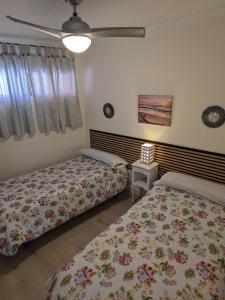 sypialnia z 2 łóżkami i wentylatorem sufitowym w obiekcie Apartamento Torremar w Alicante