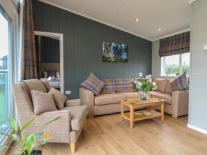 a living room with two couches and a table at Willow Lodge in Newark-on-Trent