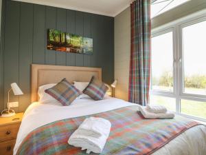 a bedroom with a bed with two towels on it at Willow Lodge in Newark upon Trent