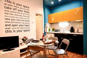uma cozinha com uma mesa com cadeiras e uma televisão em Blue home in the heart of Budapest em Budapeste