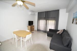 sala de estar con sofá negro y mesa en Casa Morango - Senhora da Rocha, Algarve en Porches