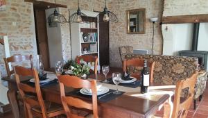 a dining room with a wooden table with wine glasses at Le Marais in Chasseneuil-sur-Bonnieure