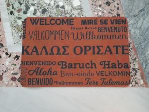 Un signo que dice bienvenida a la mía se desgastado vaughanholmholmholmholmholm en Friendly Philoxenia en Xanthi