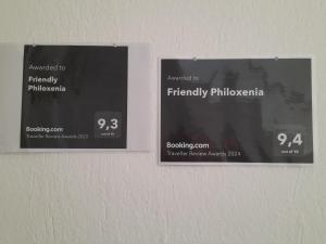 two signs on a wall with the names at Friendly Philoxenia in Xanthi