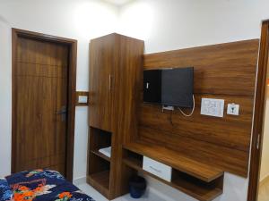a bedroom with a wooden wall with a tv on it at HOTEL HIVIN AND PEANCE - TOP RATED AND SERCH PROPERTY AMRITSAR in Amritsar
