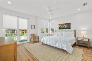 a white bedroom with a bed and a table at Endless Summer Oasis Heated Pool And Putting Green in Saint Augustine Beach