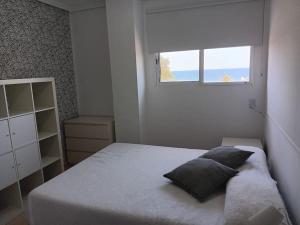 a small bedroom with a bed with a window at Apartamento en Xilxes con preciosas vistas al mar in Chilches