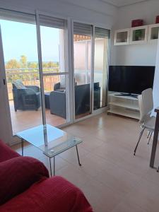 a living room with a couch and a glass table at Apartamento en Xilxes con preciosas vistas al mar in Chilches