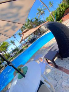 璜多里奧的住宿－迪芙蘭切斯旅館，游泳池旁的遮阳伞和椅子
