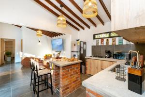 a kitchen with a brick island in the middle at Sweet Helen Llanogarden in Rionegro