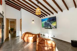 a living room with a couch and a flat screen tv at Sweet Helen Llanogarden in Rionegro