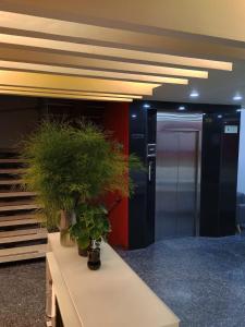 - un hall doté d'un bureau avec des plantes en pot dans l'établissement HOTEL SHERIDAN BOGOTA, à Bogotá