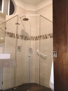 y baño con ducha y puerta de cristal. en HOTEL SHERIDAN BOGOTA, en Bogotá