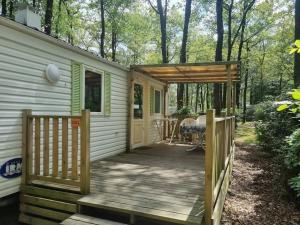 a house with a wooden porch and a deck at Mobile home 5 pers en campagne Proche Puy du fou 110CB in La Boissière-de-Montaigu