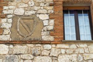 a stone building with a window and a sign on it at Doña Elvira y Doña Sol in Vivar del Cid