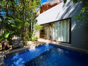 una piscina en el patio trasero de una casa en Kuun Taak Tulum, en Tulum